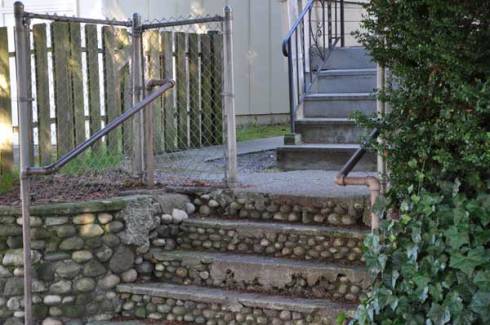 chain-link, pipe railing, fabricated railing, wood fence and cobblestone steps.